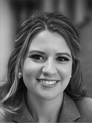 Black-and-white headshot of a smiling professional woman wearing a blazer.