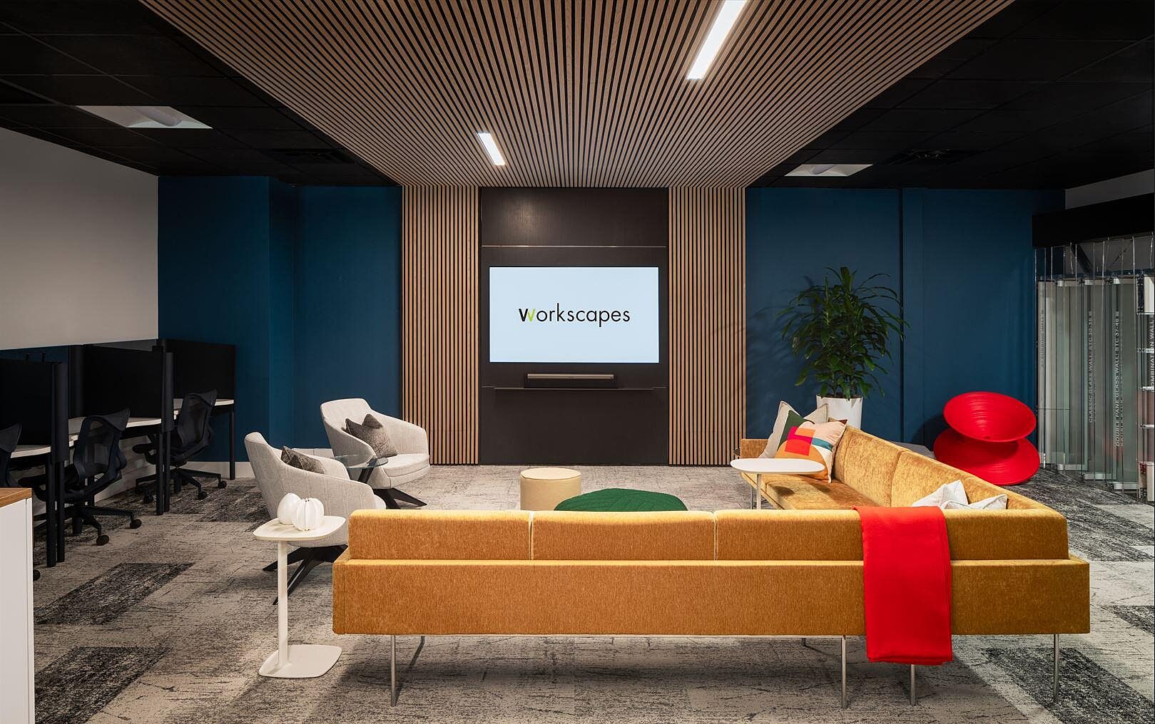 Modern Workscapes showroom with lounge seating, bold colors, and screen with logo.