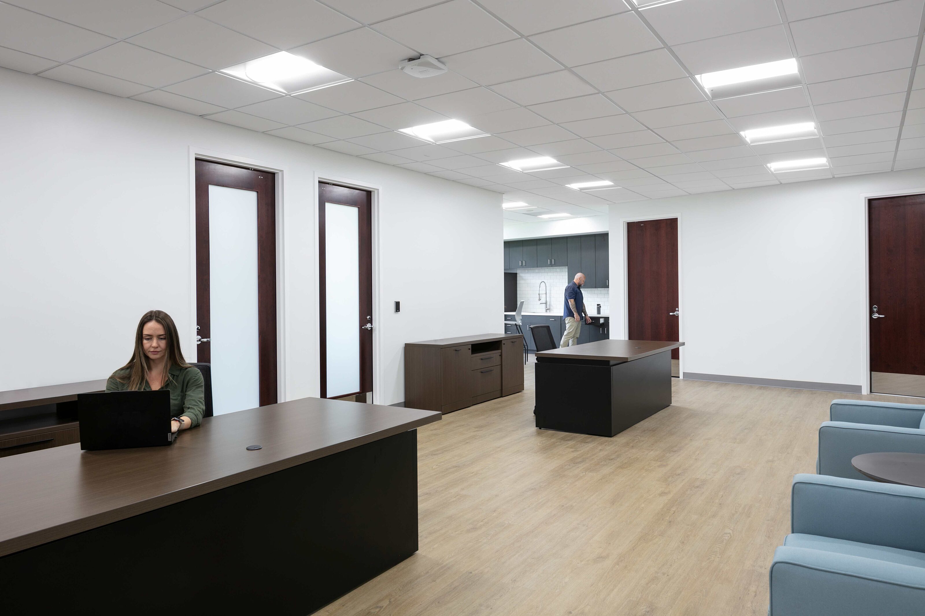 Modern administration office with private work areas, reception seating and employees at work.