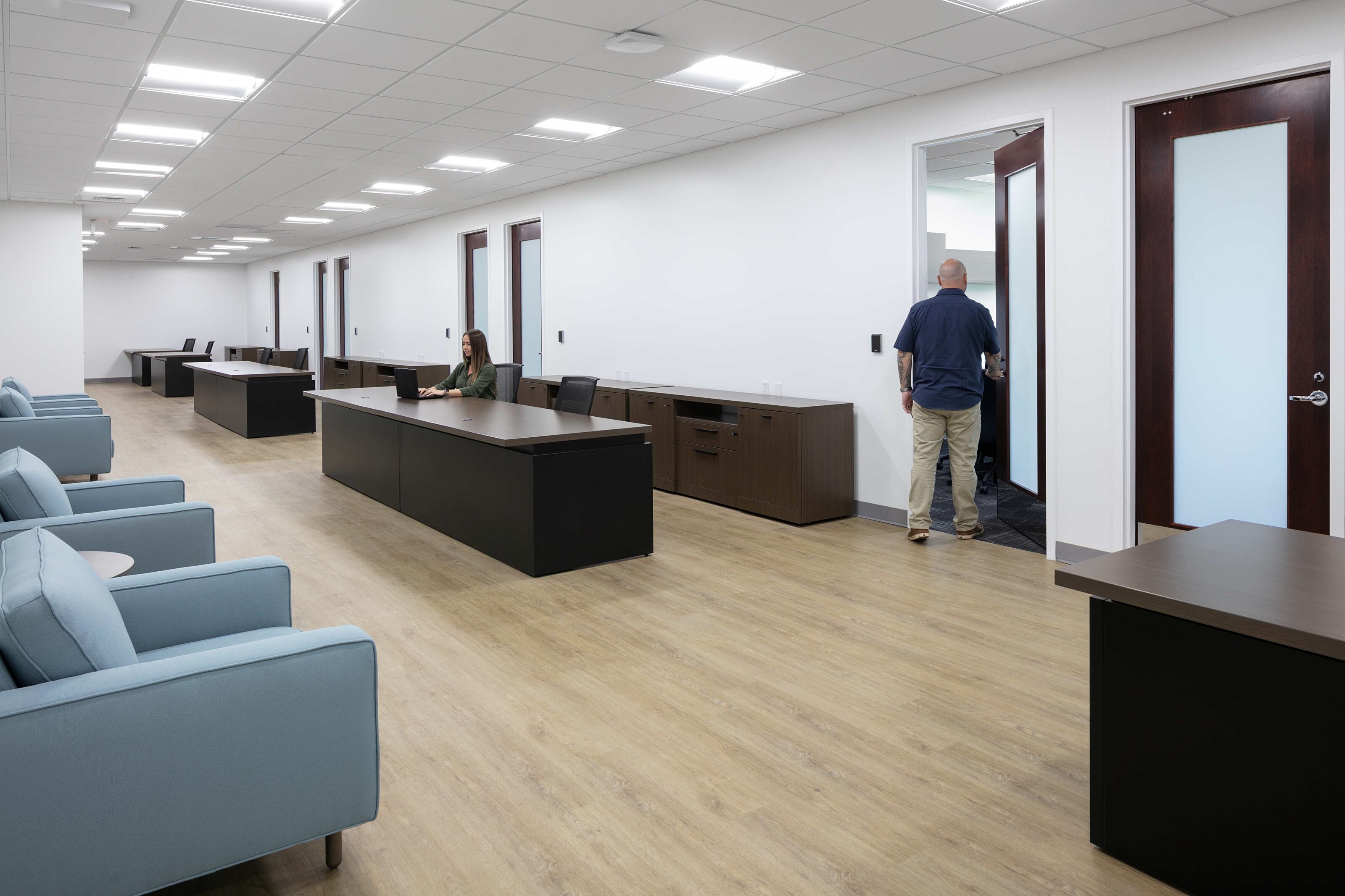 Administration office with private workstations, lounge seating and employees working.