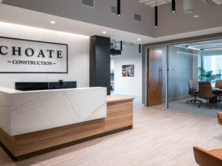 Reception area with Choate Construction sign, modern desk, and glass-walled conference room.