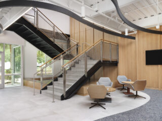 Modern lobby with staircase and collaborative seating.