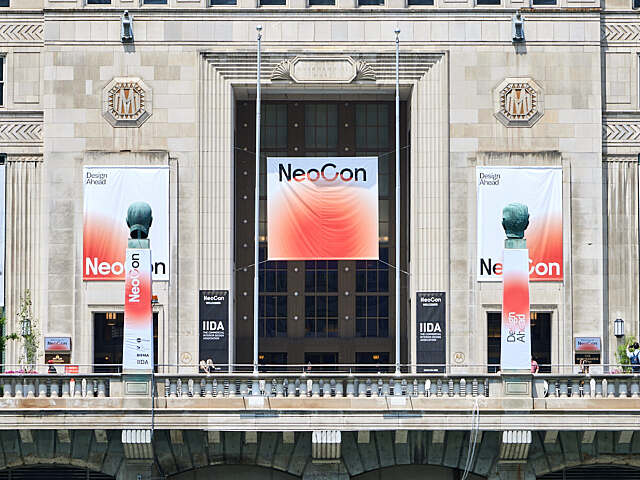 Front exterior view of THE MART building in Chicago displaying large NeoCon event banners across the historic stone façade.
